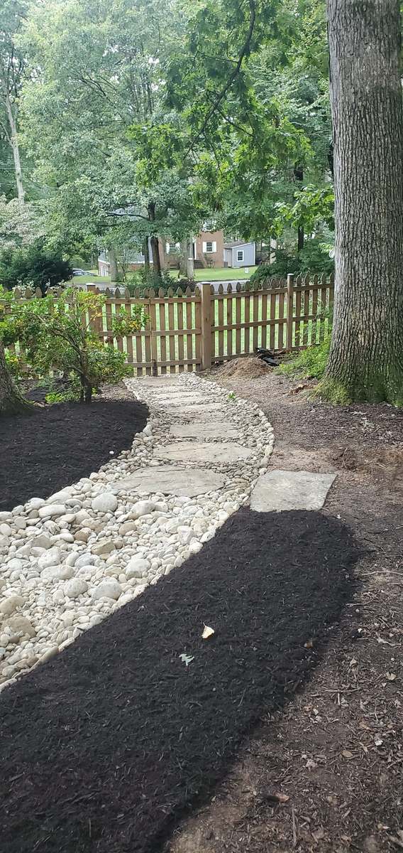 Finished dry-creek drainage route with stone and landscape restoration