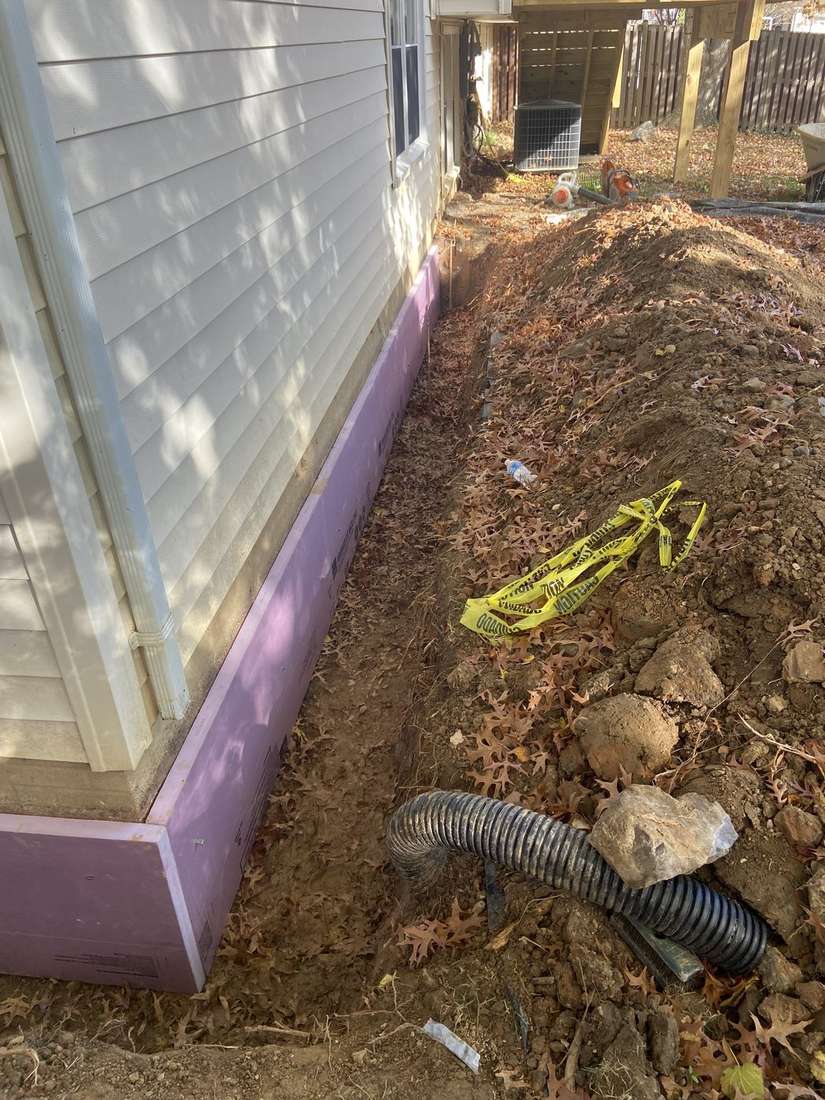 Rigid protection installed along an exposed exterior foundation wall