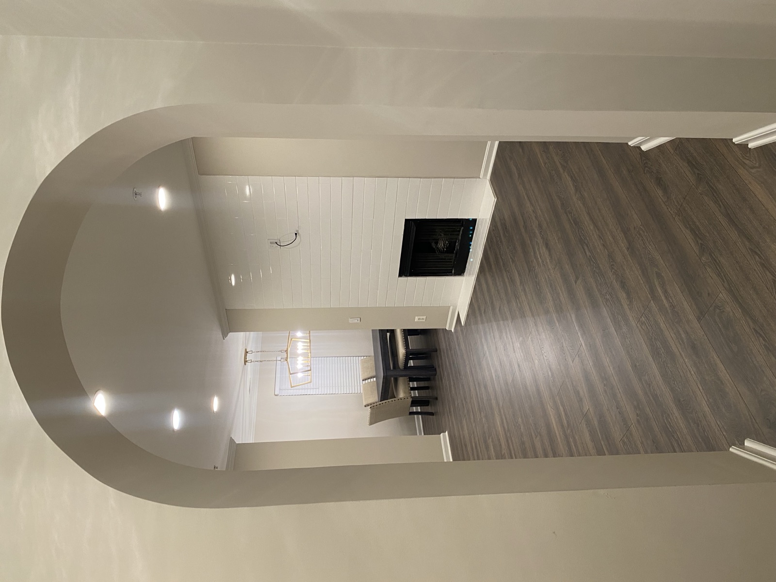 Finished interior renovation with flooring, lighting, fireplace, and architectural opening
