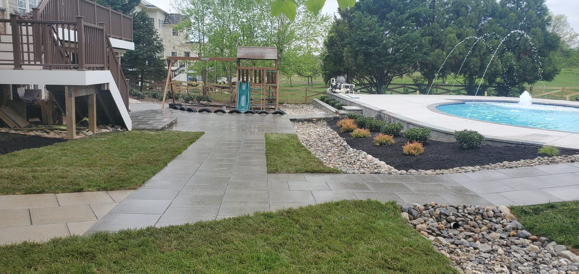 Completed whole-property renovation with grading, walkways, decorative stone, planting beds, and lawn restoration